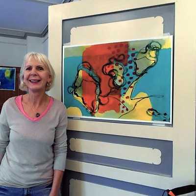 Doris Müller steht vor einem ihrer Gemälde